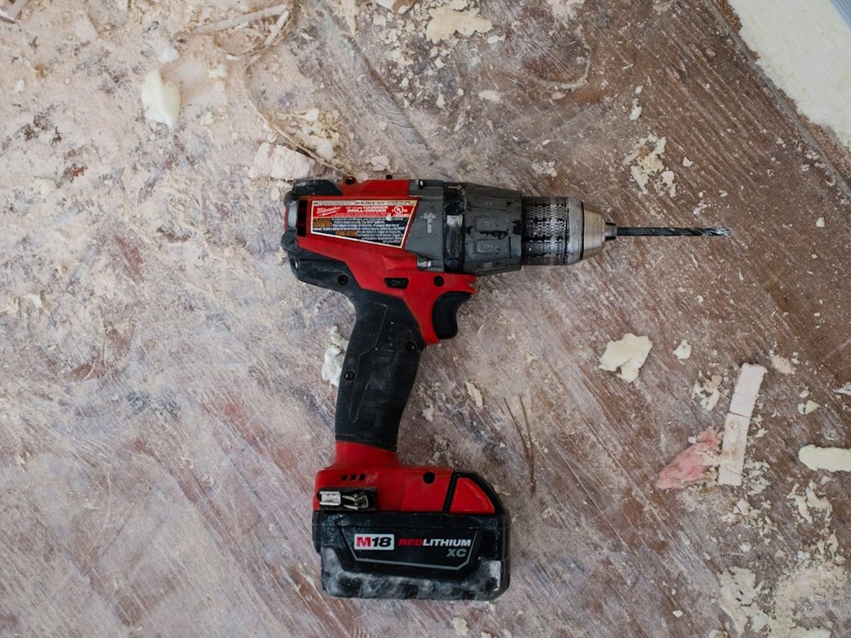 Cordless drill resting on a job-site floor during home repair